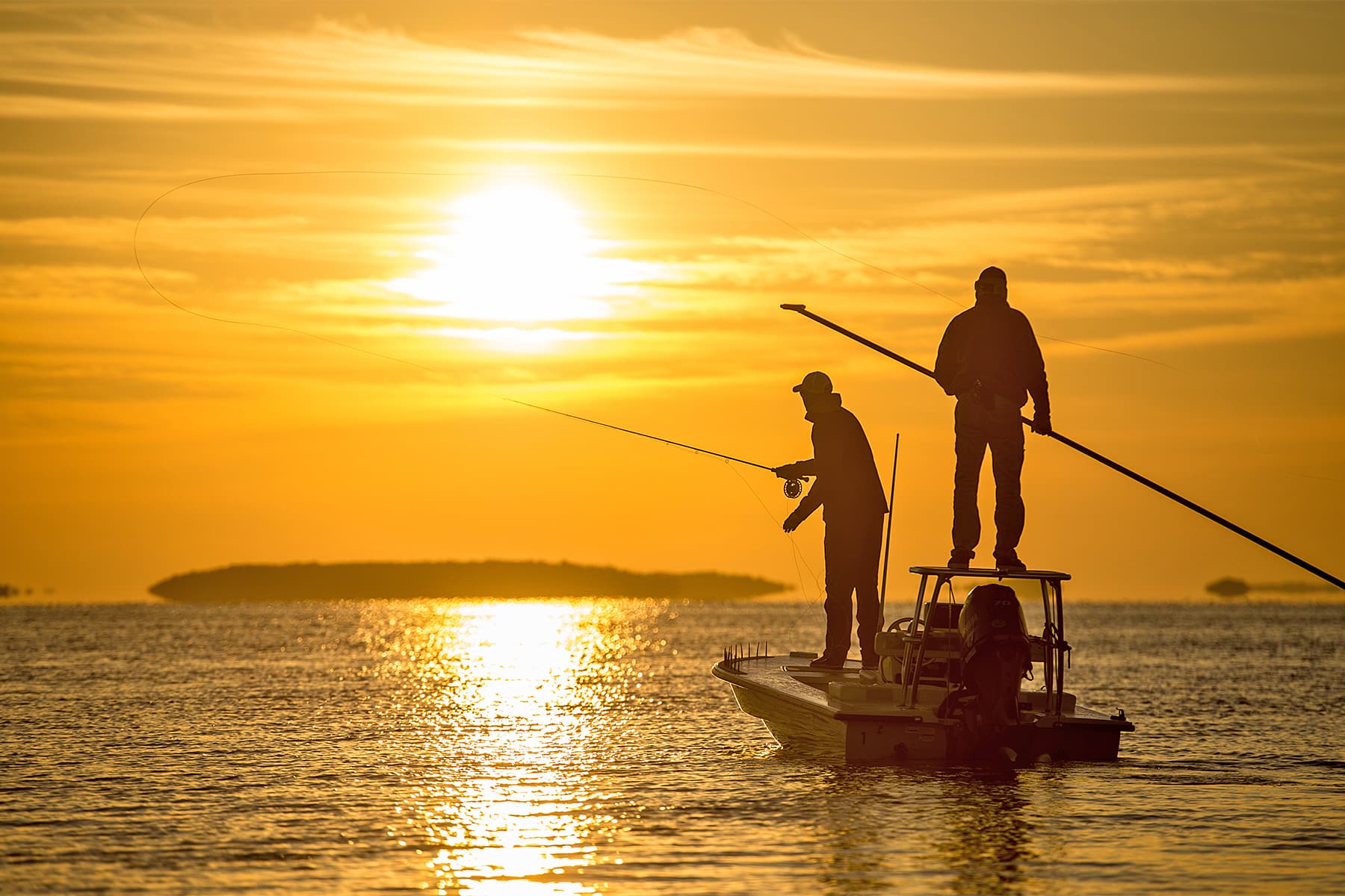 Charter anglers silhouetted against a golden sunset